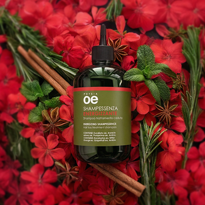 immagine del prodotto dello shampessenza energizzante ambientato su fiori rossi, con delle foglie di rosmarino e cannella